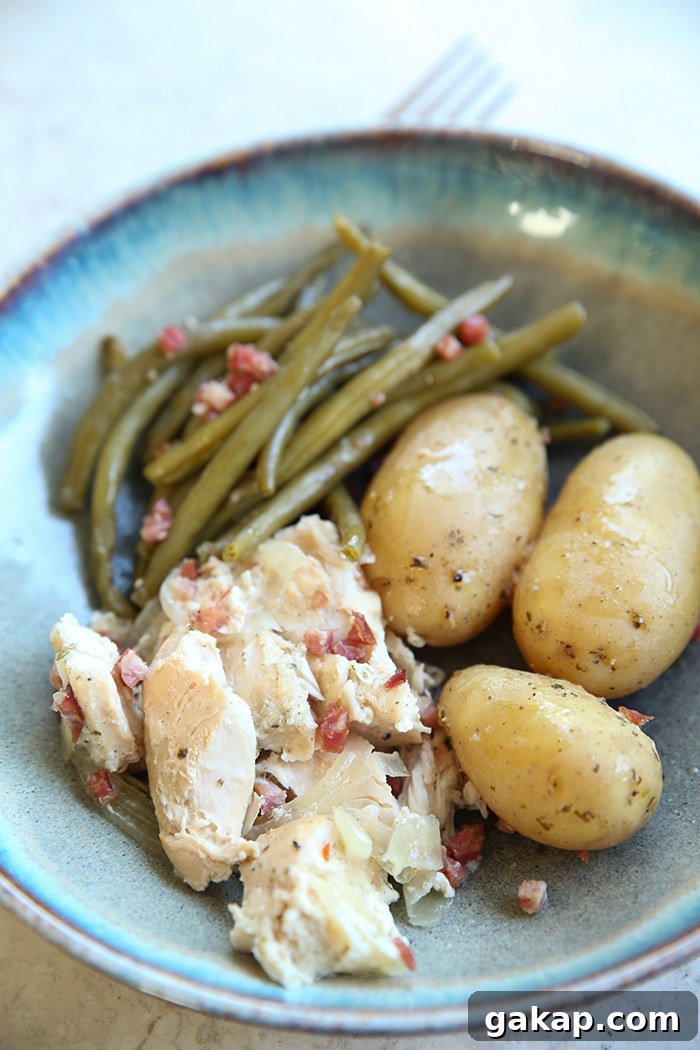 A dinner bowl plate with a serving of green beans and chicken with bacon pieces, and three baby potatoes.