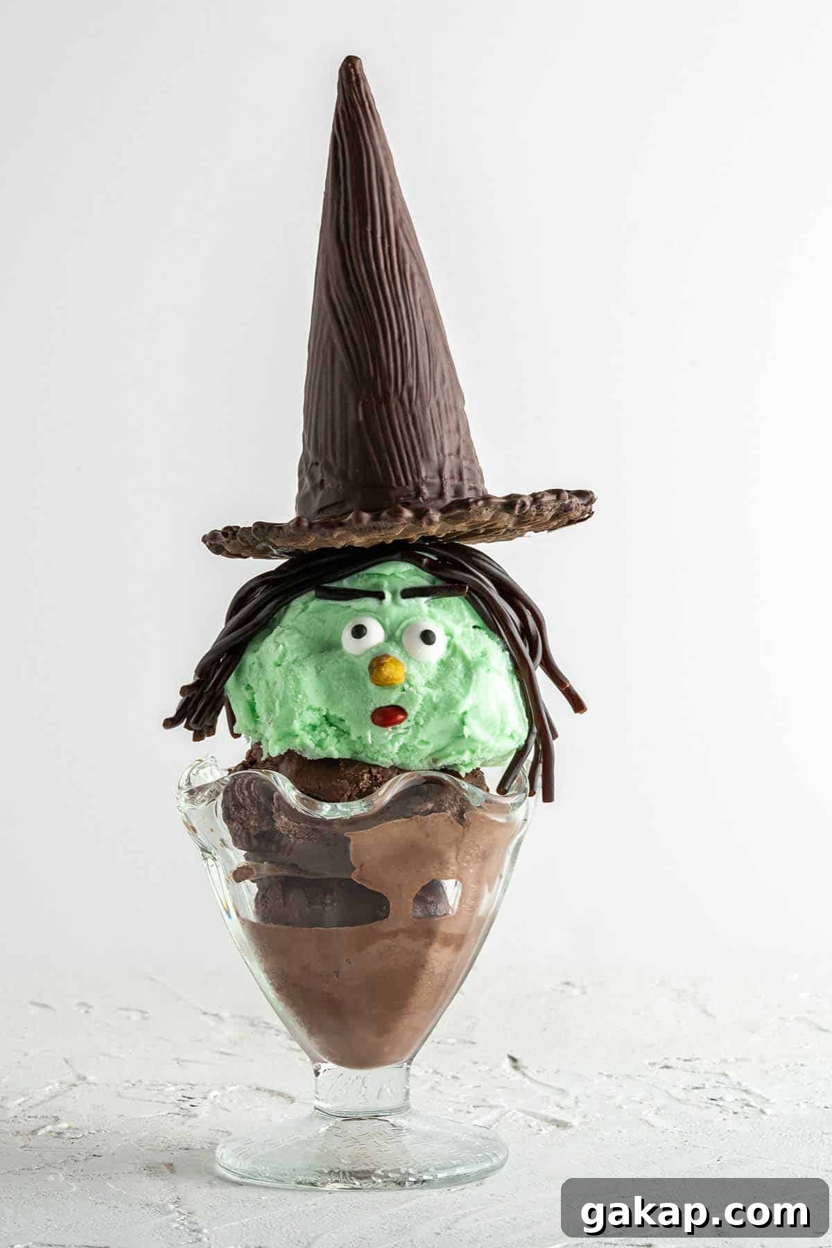 side view of witch Halloween sundae with white background