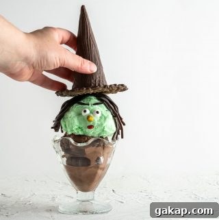 hand placing hat on top of Halloween witch ice cream sundae