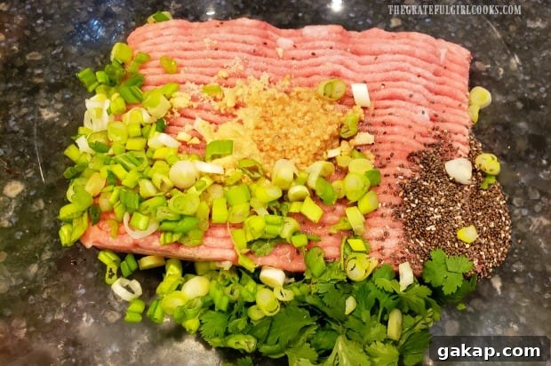 Ground turkey with chopped onions, cilantro and spices, ready to make Thai turkey meatballs.