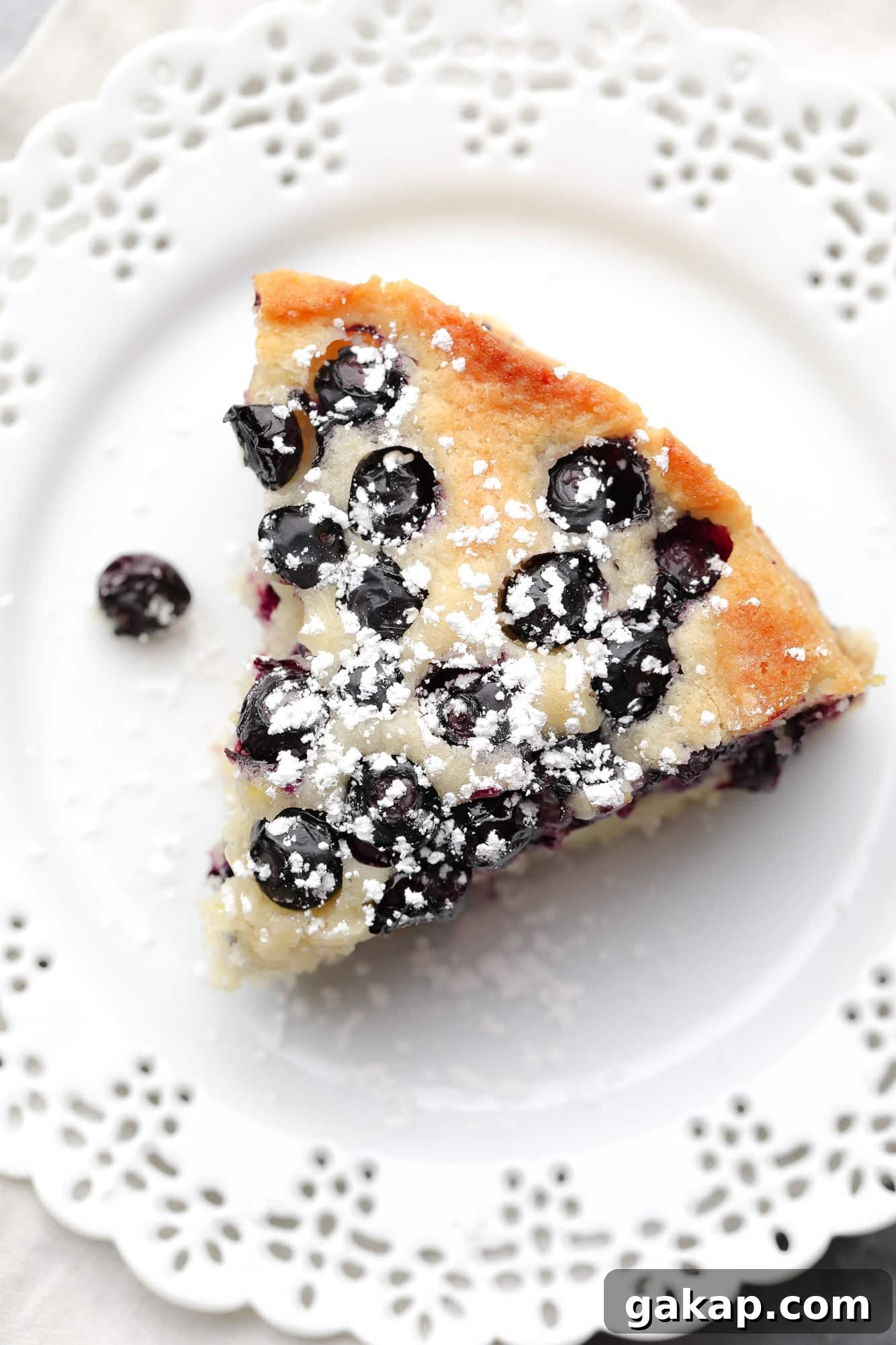 Moist Vegan Blueberry Layer Cake Recipe 7 a slice of vegan blueberry cake on a white plate.
