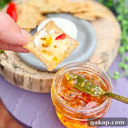 hot pepper jelly served on a cracker with creamy cheese