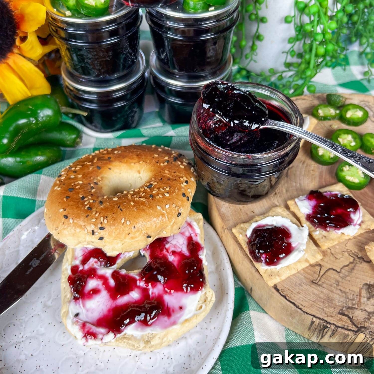 bagel with cream cheese and jelly next to crackers and jelly and jelly jar