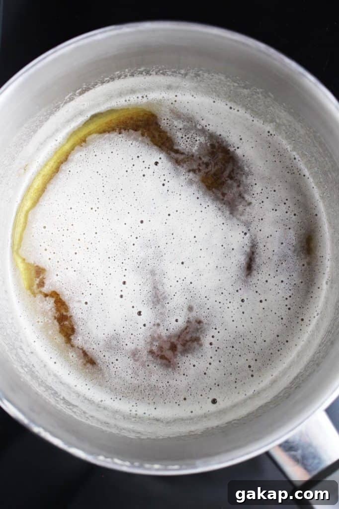 Brown butter in a light-colored saucepan for making brown butter cream cheese frosting to go on moist carrot cake
