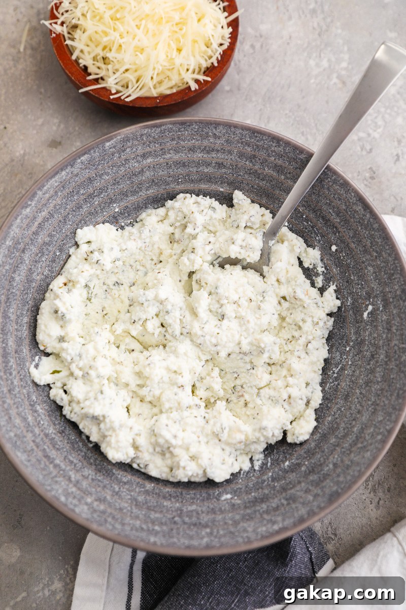 A small bowl filled with herbed ricotta for chicken meatballs