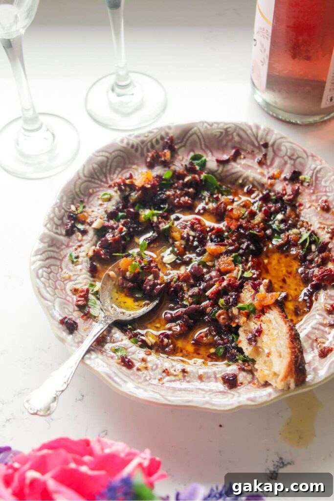 Date night bread dipping oil on a pink plate with a silver spoon.
