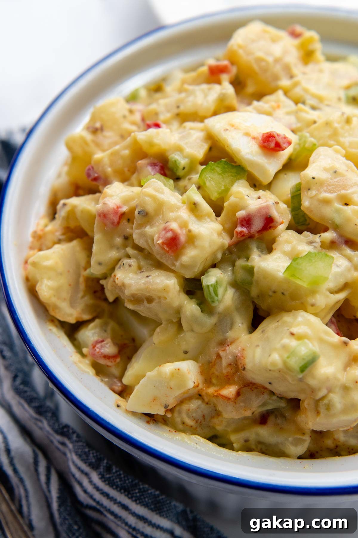 a close up of the top of potato salad in a white serving bowl.