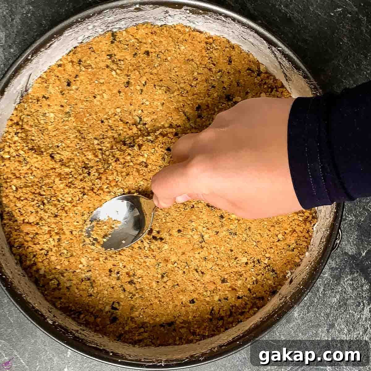 Create the crust by pressing the crumbs inside the pan.