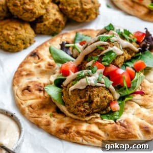 completed Healthy Baked Falafel on bread against a white background