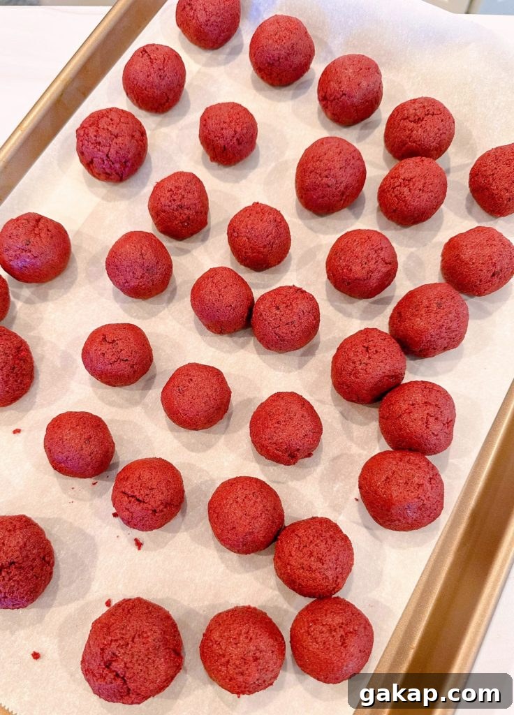 Red Velvet Cake Pops: Simple Party Dessert Recipe 6 Cake balls are rolled and placed on a parchment-lined baking sheet.