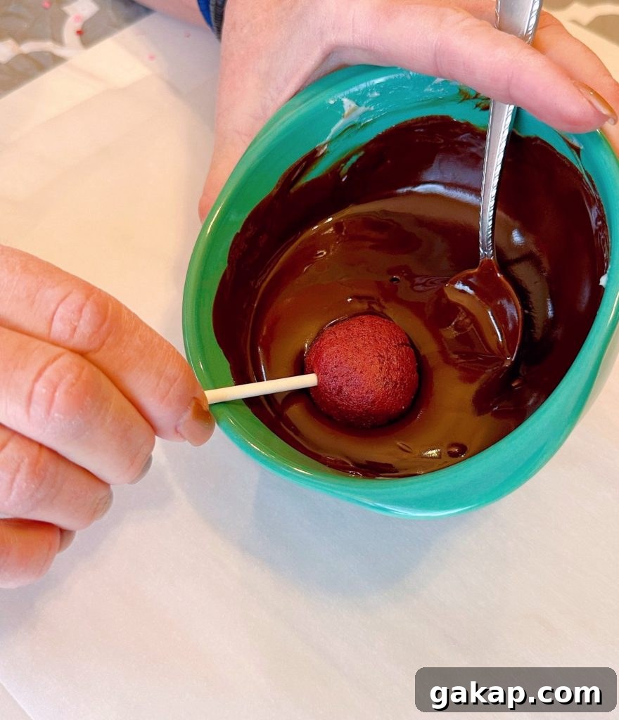Red Velvet Cake Pops: Simple Party Dessert Recipe 7 Dipping cake pops into melted chocolate.