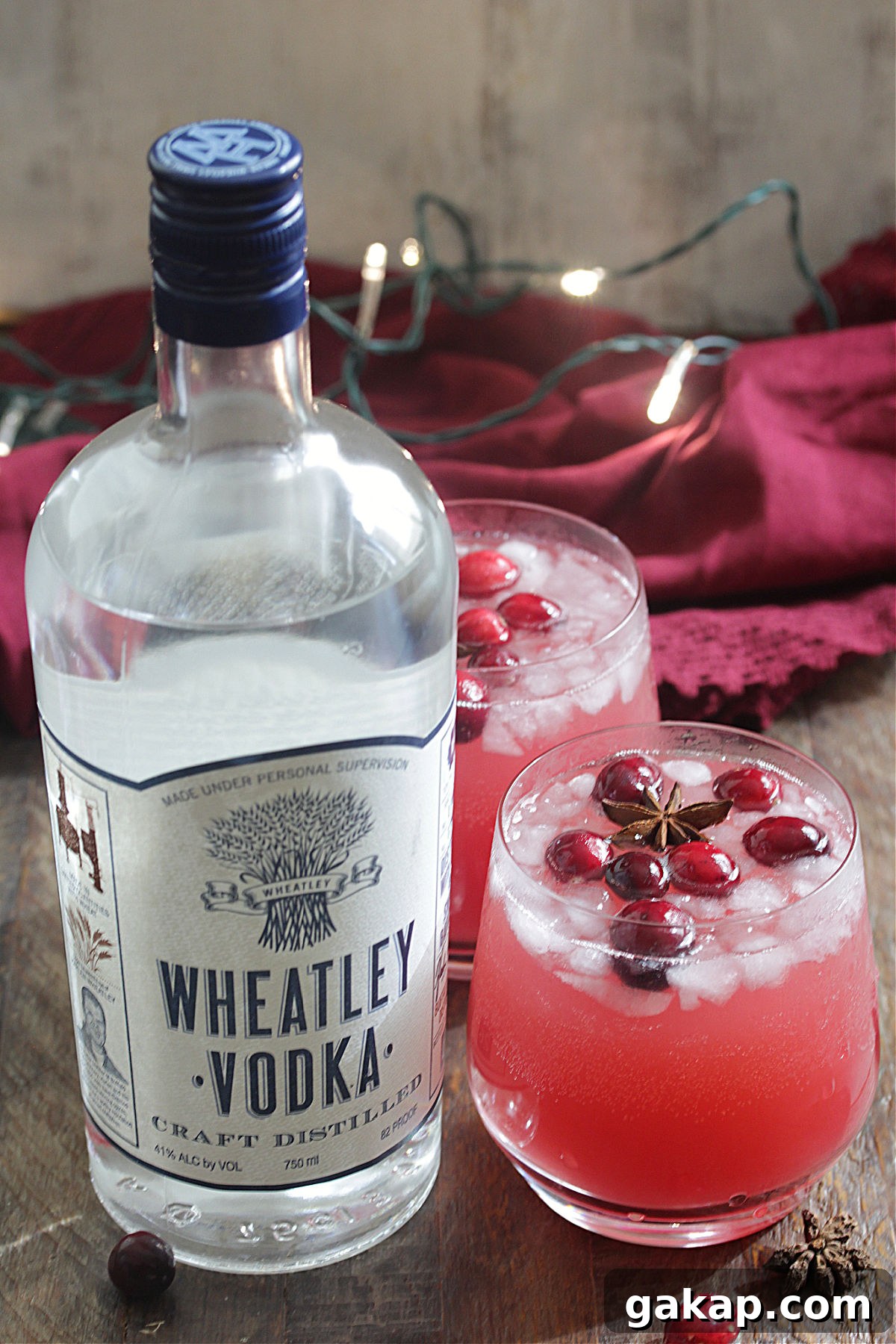 Festive Vodka Sippers: Holiday Cocktail Ideas for Parties 2 Bottle of Wheatley Vodka next to red holiday drink with cranberries