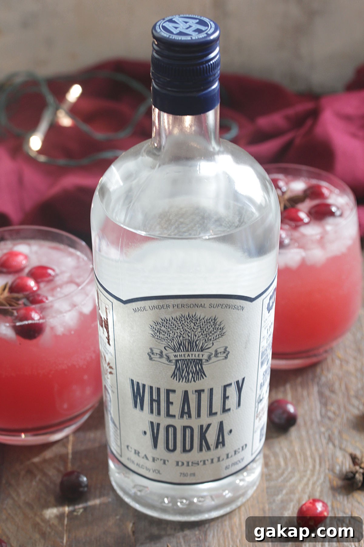 Festive Vodka Sippers: Holiday Cocktail Ideas for Parties 3 Bottle of Wheatley Vodka next to red holiday drink with cranberries