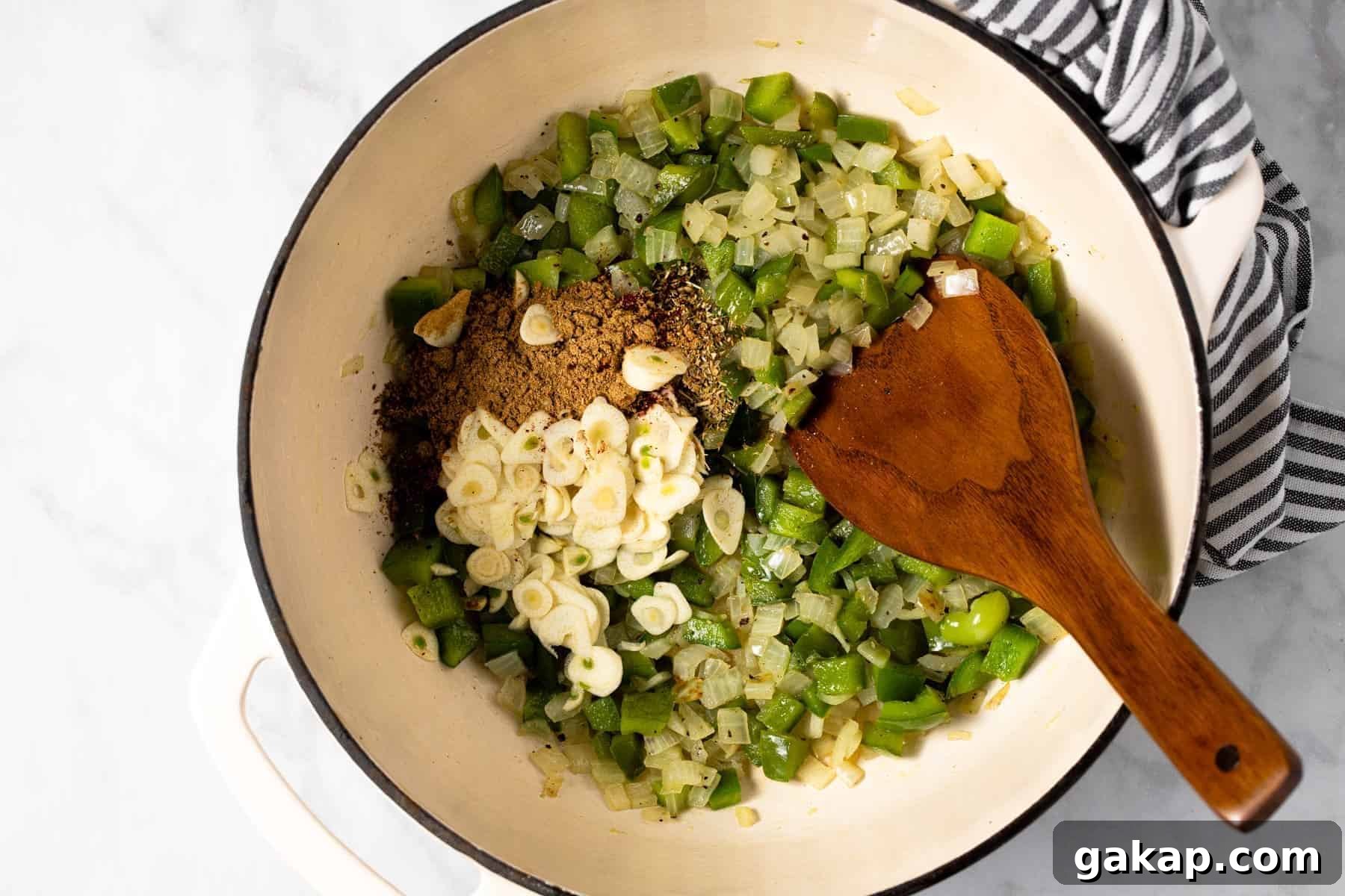Large white pot filled with sauteed veggies garlic and spices
