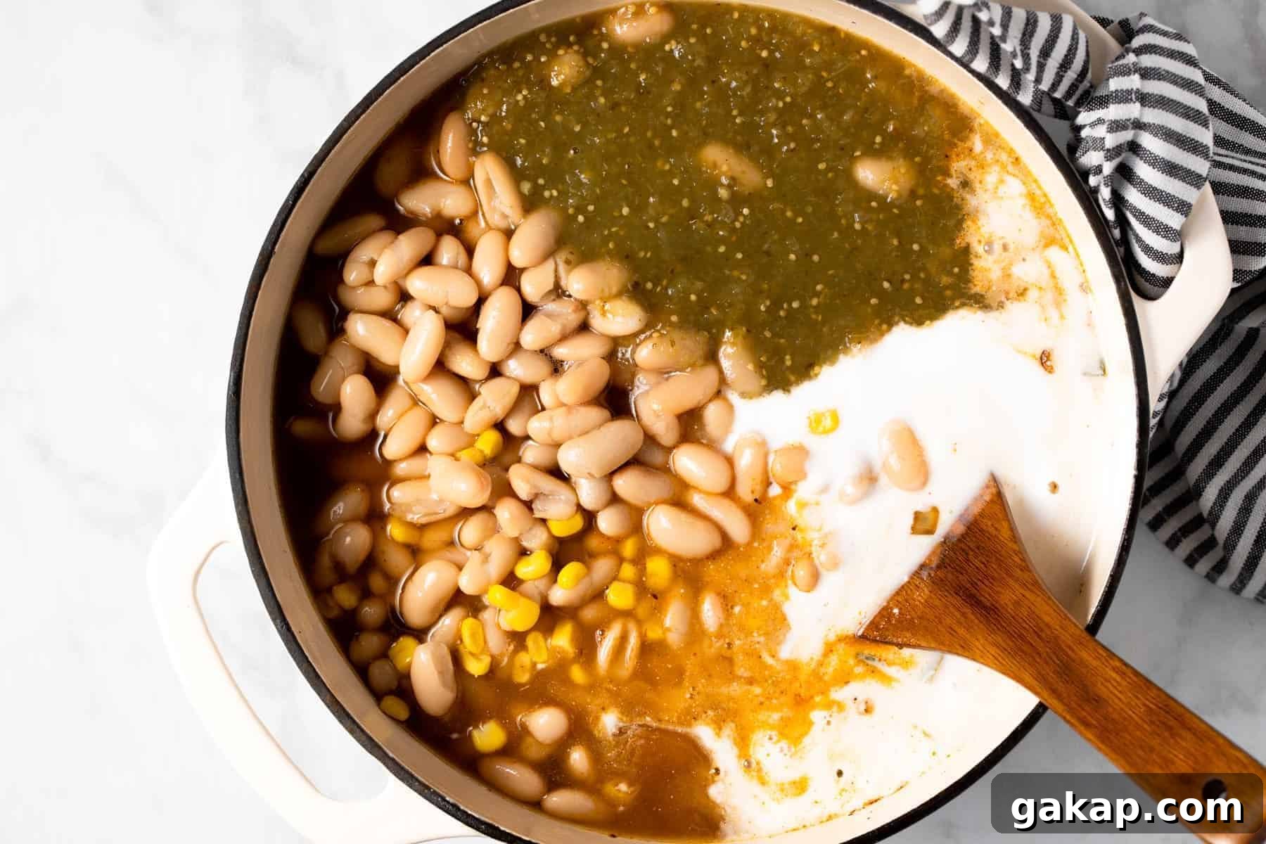 Large white pot filled with ingredients to make white bean chili