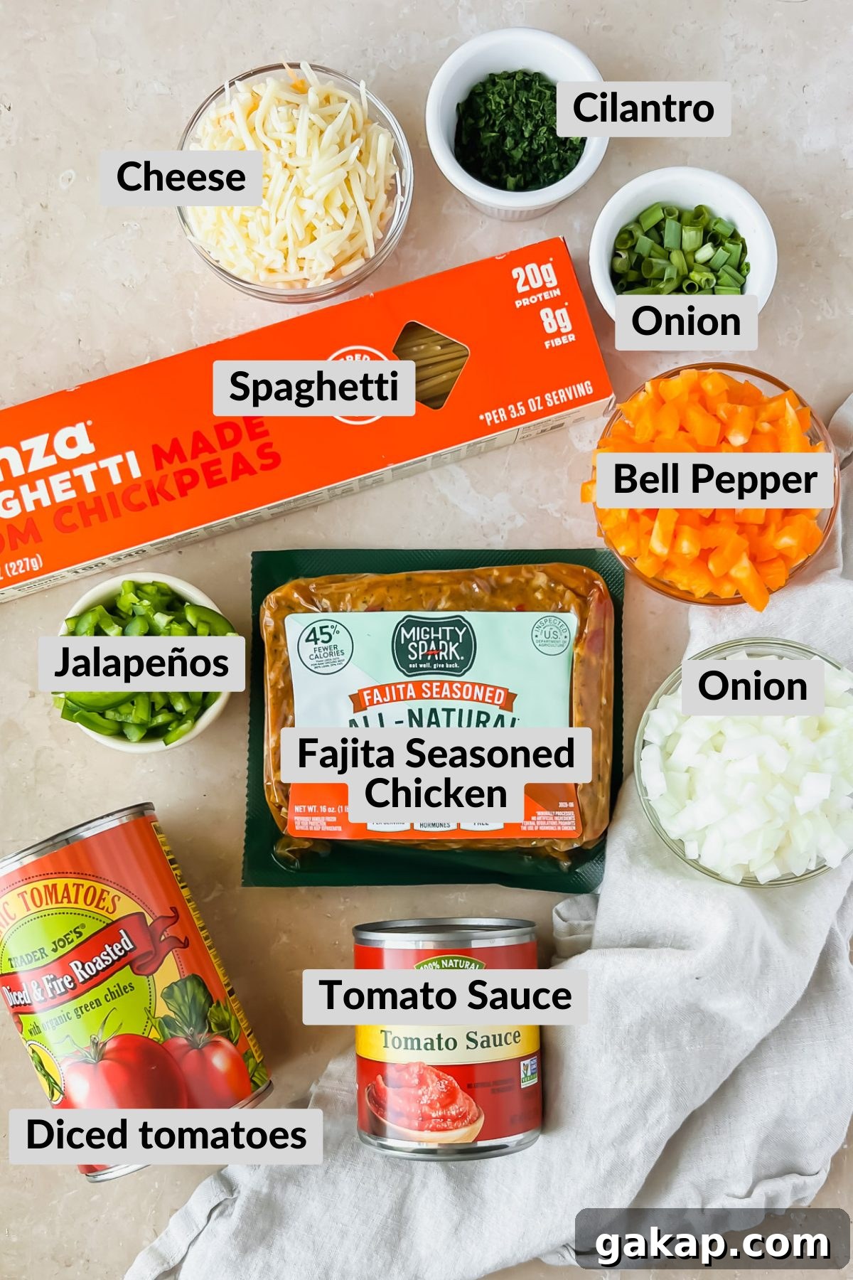 ingredients for mexican spaghetti in individual bowls spread on tan background.