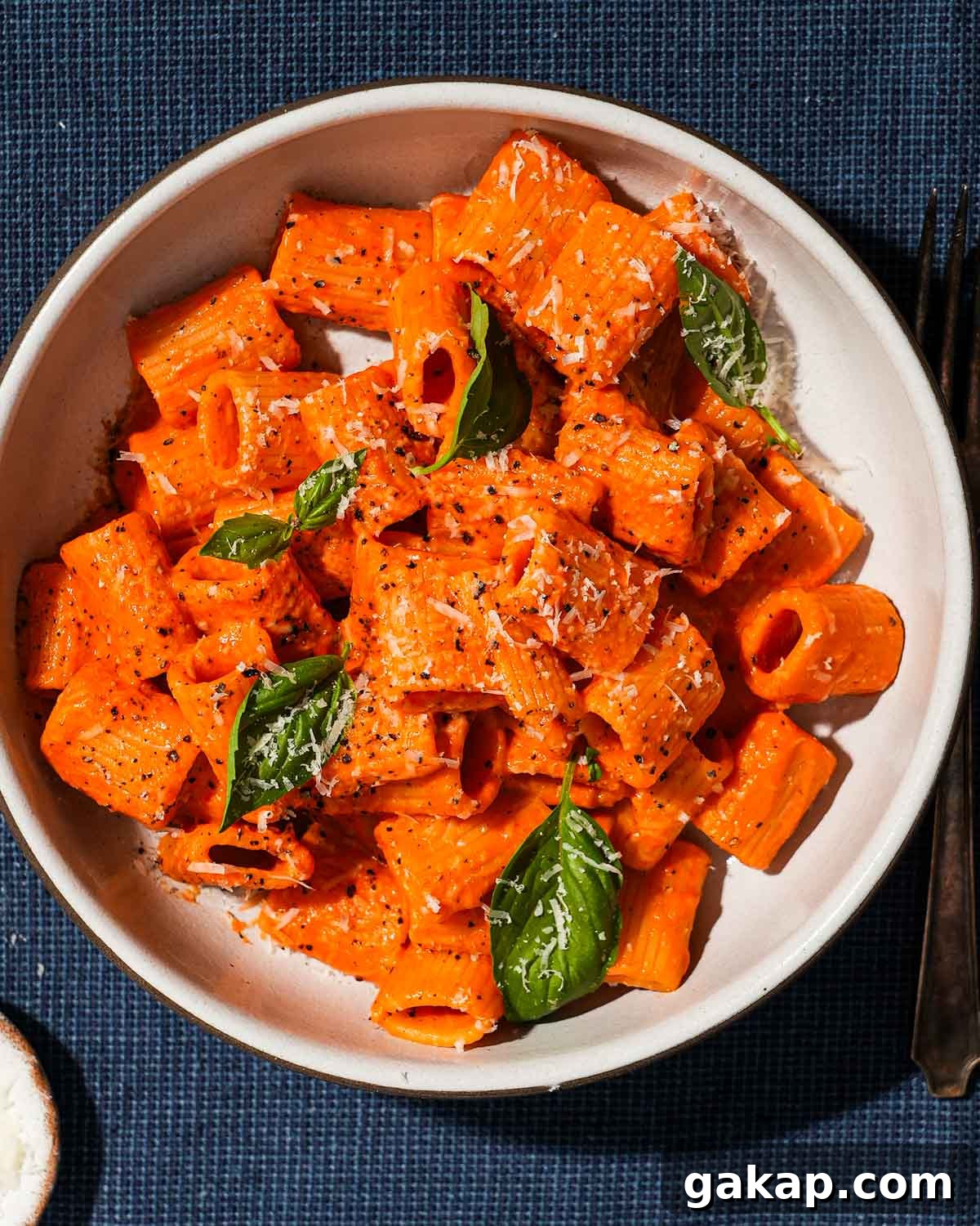 Creamy Roasted Red Pepper & Tomato Pasta Recipe 2 A large shallow bowl of roasted red pepper and tomato pasta with basil.