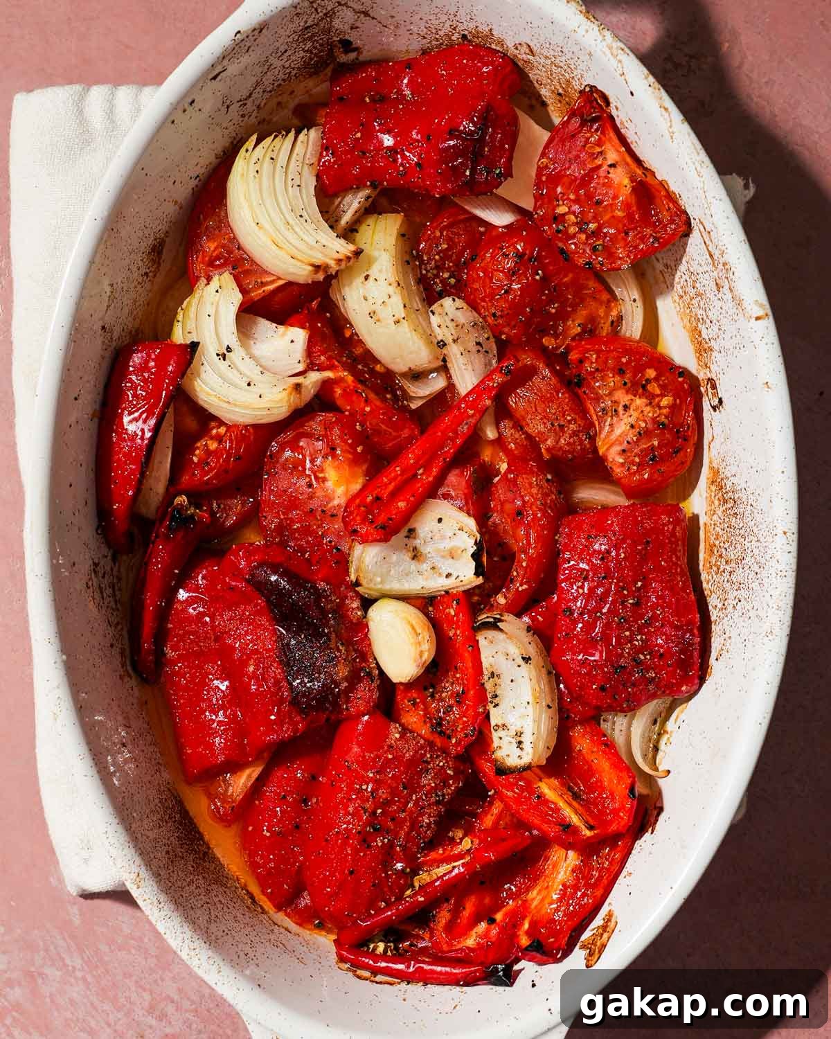 Creamy Roasted Red Pepper & Tomato Pasta Recipe 5 A white tray of roasted red peppers, tomato, garlic, and onion ready to be blended.