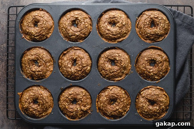 Gluten-Free Carrot Cake Donuts: Soft Spiced Donut Recipe 8 Baked donuts cooling in the pan on a wire rack.