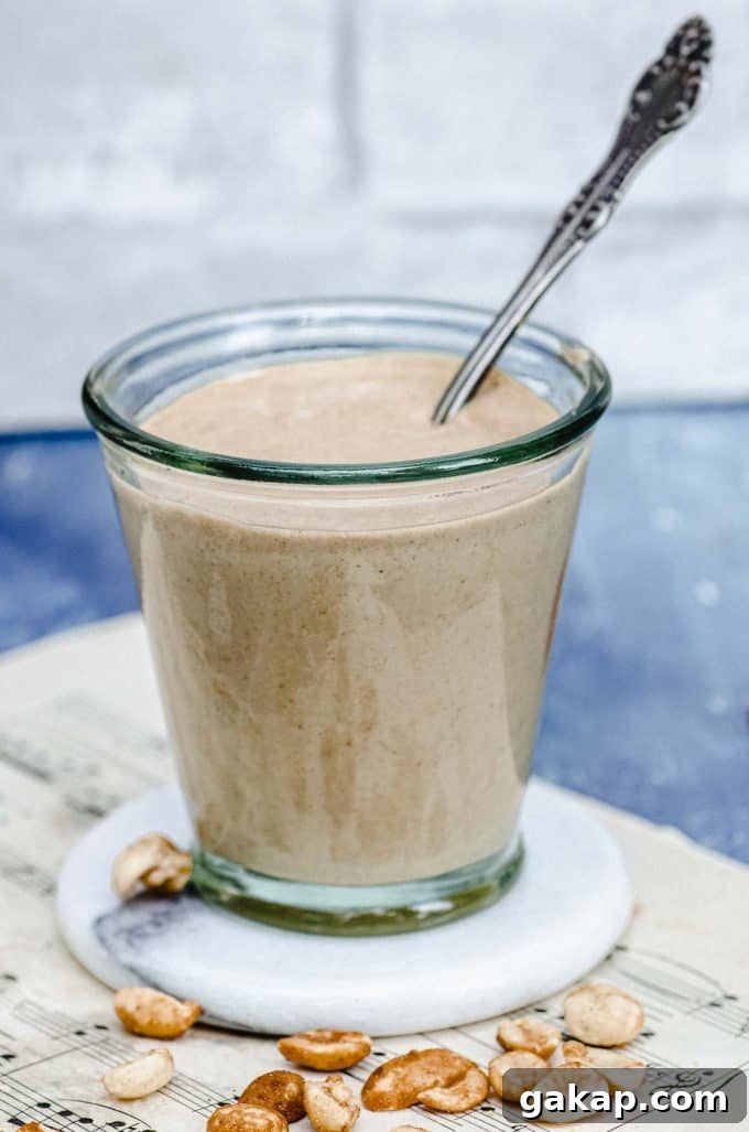 Side close up view of a glass cup with-peanut dressing