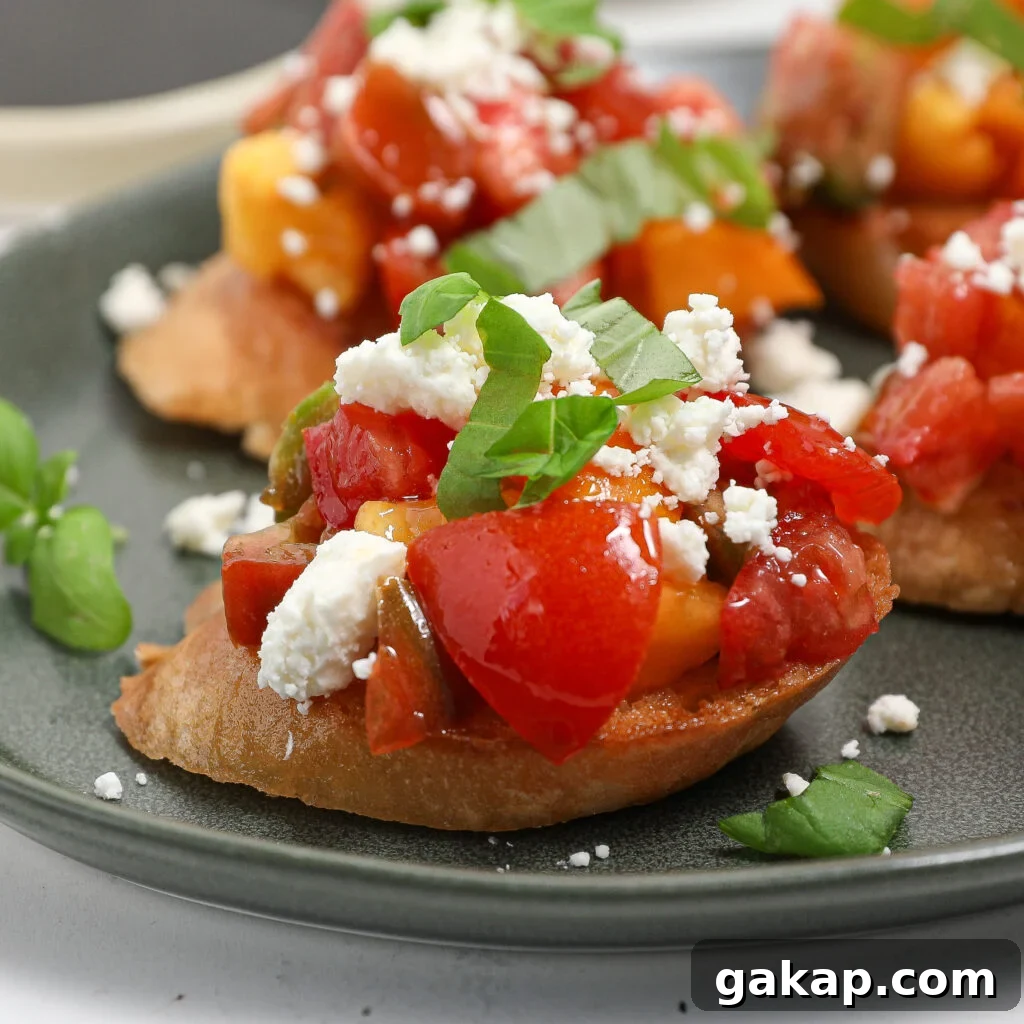 Tomato and Feta Bruschetta Recipe: Fresh Mediterranean Appetizer 2 A close-up of tomato feta bruschetta topped with diced tomatoes, yellow peppers, crumbled feta cheese, and fresh basil, served on a green plate.