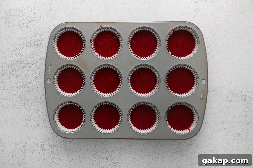Decadent Red Velvet Cupcakes with Cream Cheese Frosting 8 cupcake tin filled with batter