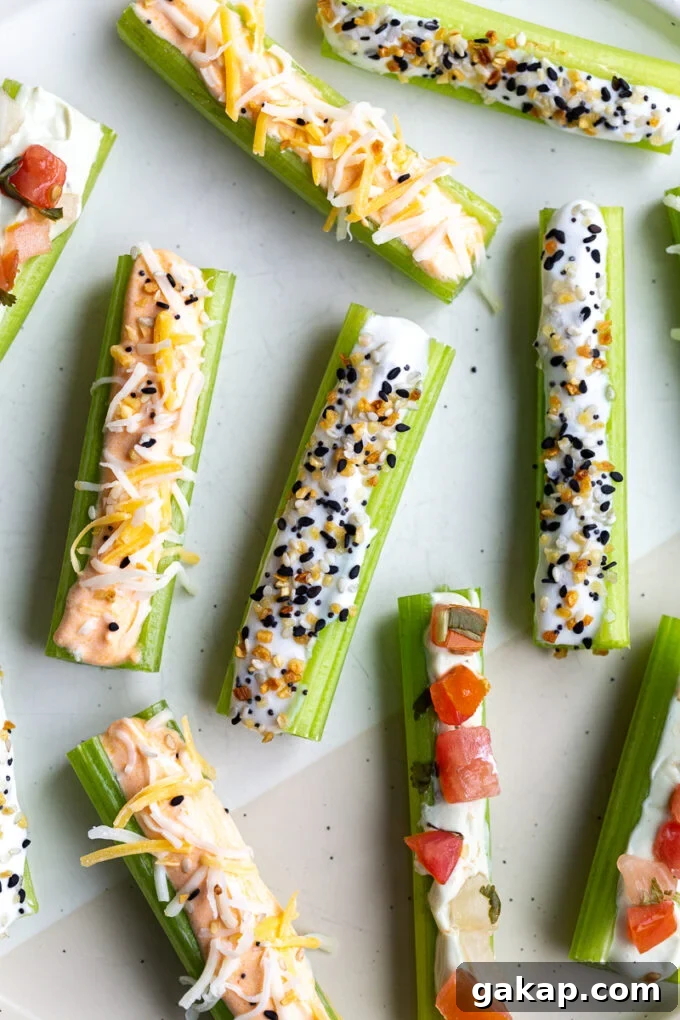 celery sticks on a white plate flavored 3 different ways: whipped buffalo cottage cheese topped with shredded cheese, whipped cottage cheese topped with everything but the bagel seasoning, and whipped avocado cottage cheese topped with pico de gallo