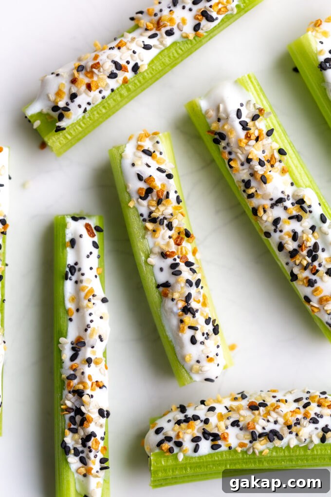 celery sticks on a plate topped with whipped cottage cheese and everything but the bagel seasoning