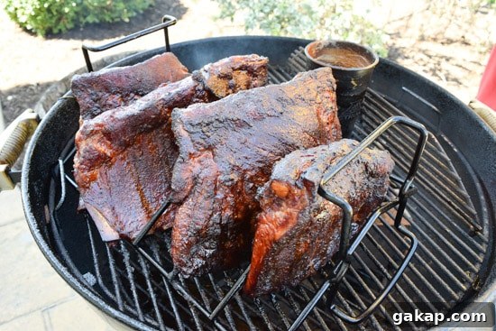 ribs being smoked in a rib rack on weber grill close up view