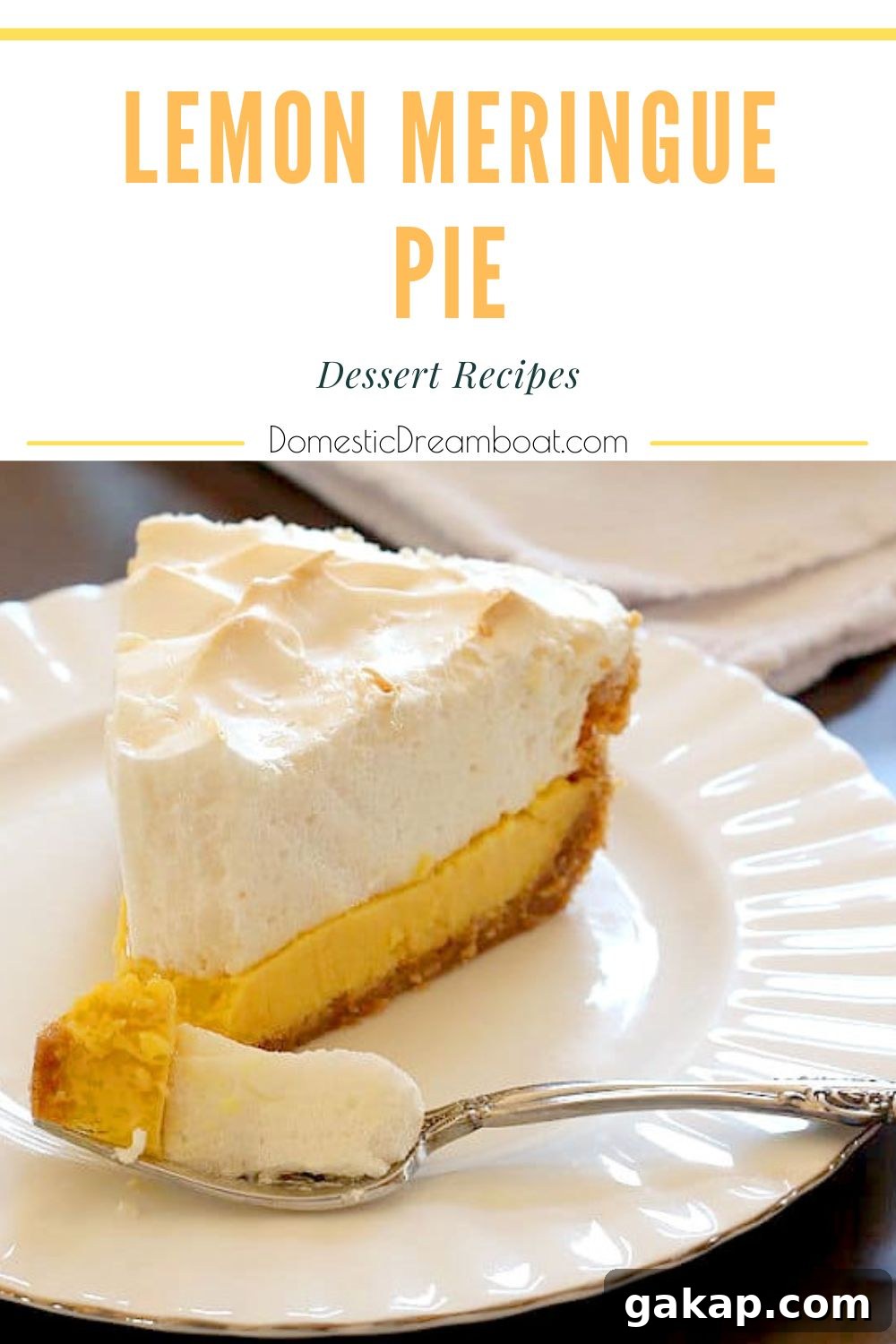 A slice of Homemade Lemon Meringue Pie on a white plate.