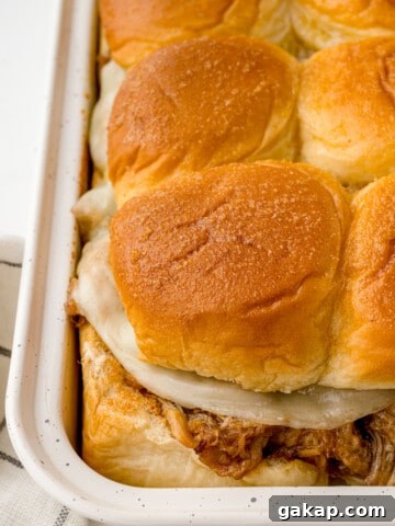 Pulled pork sliders with cheese in a pan.