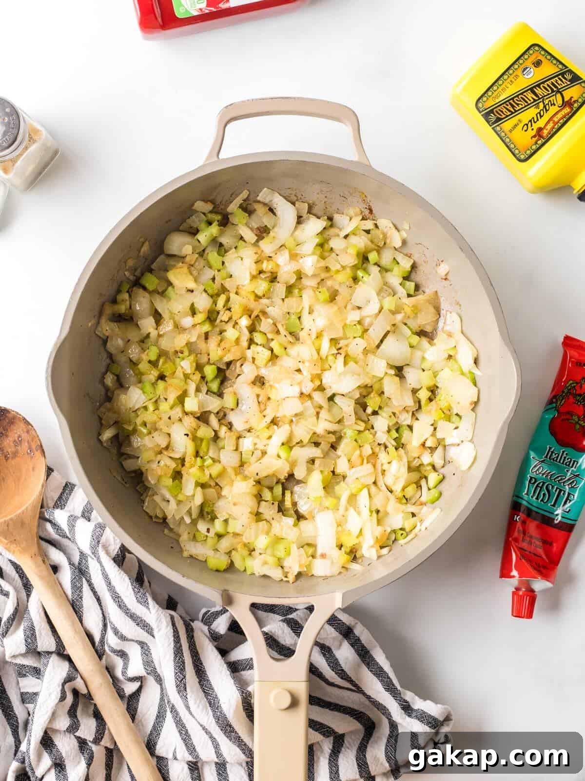 Sautéed onions, celery, and garlic in a skillet.