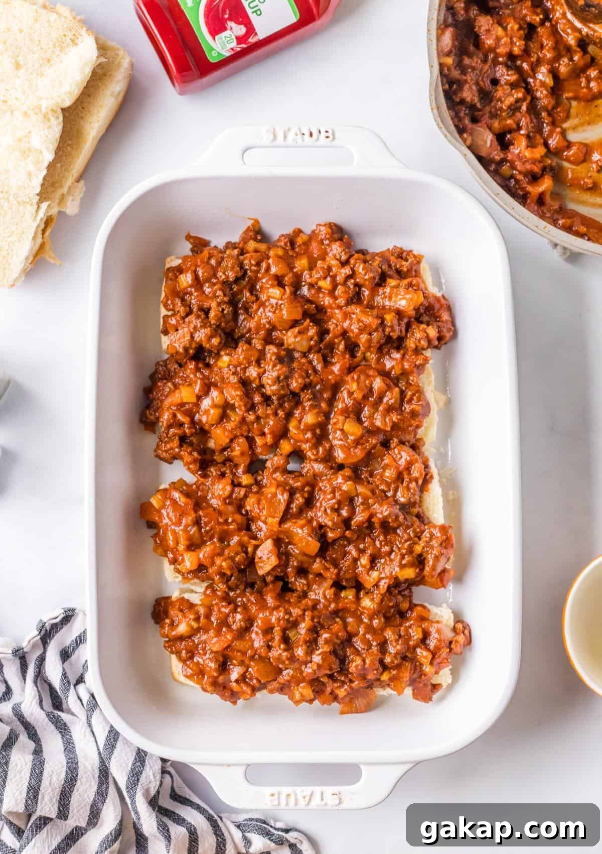 Layering ground beef filling and on Hawaiian rolls.