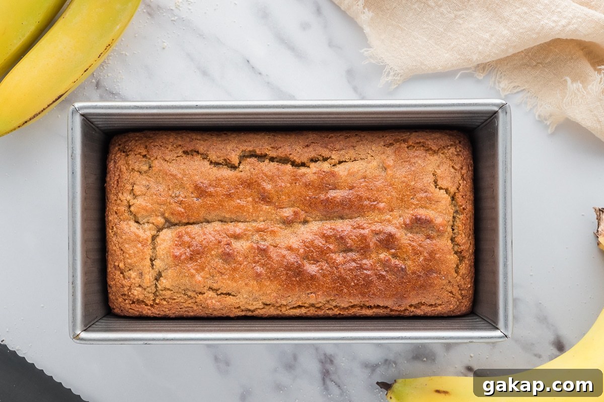 Full loaf of almond flour banana bread in a silver baking tray viewed from above.