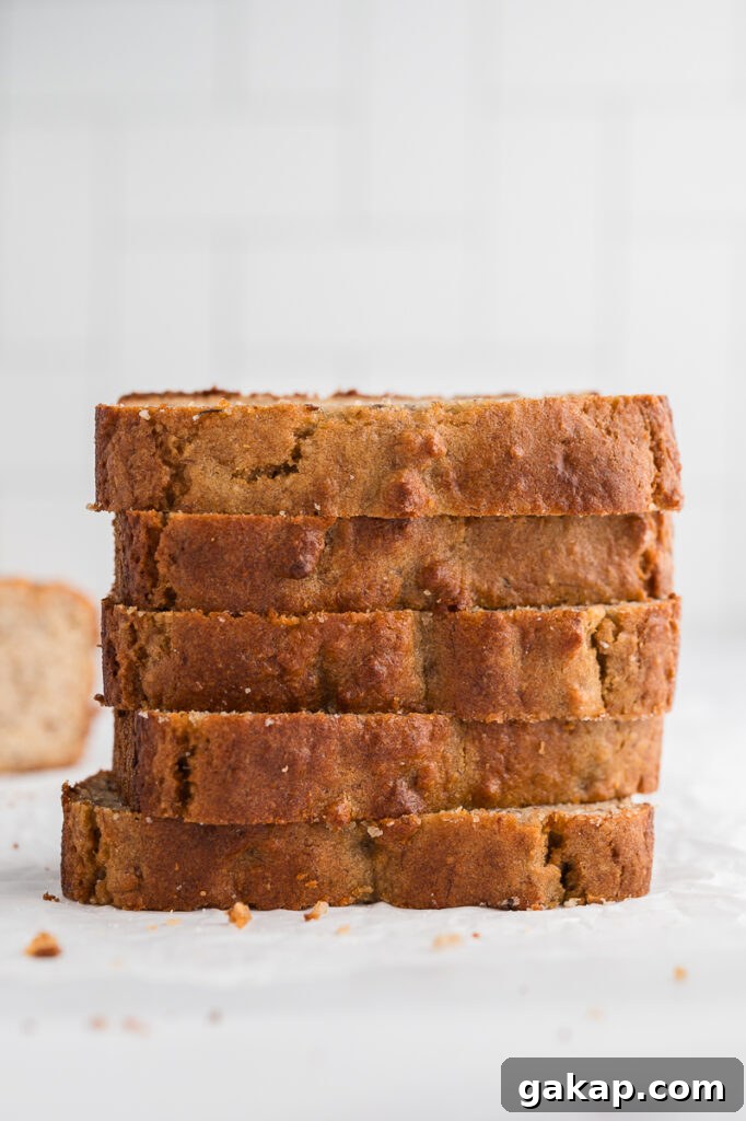 A thick slice of almond flour banana bread showing moist crumb and golden edges on a plate.
