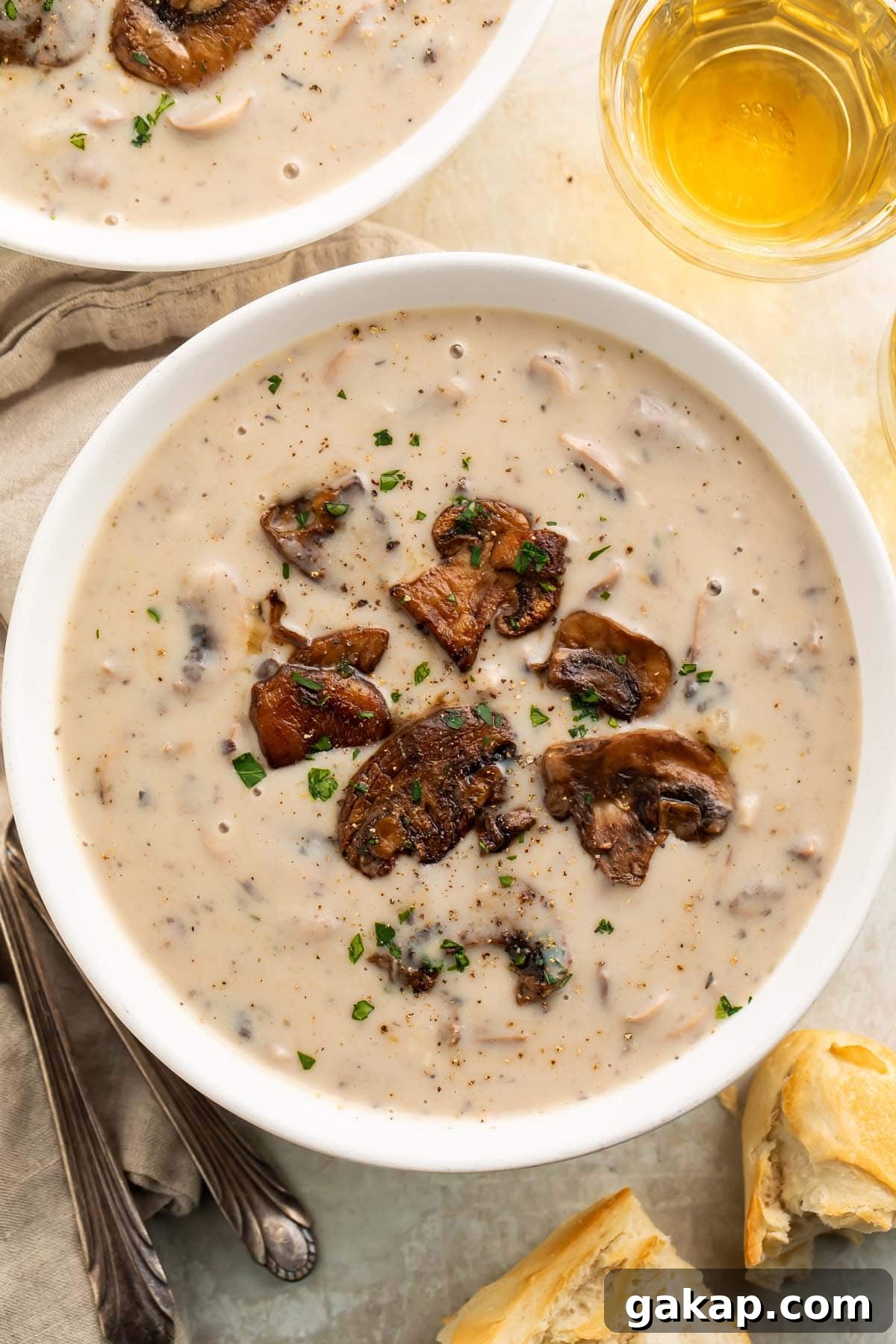 A full bowl of creamy gluten-free cream of mushroom soup garnished with rich sauteed mushrooms.