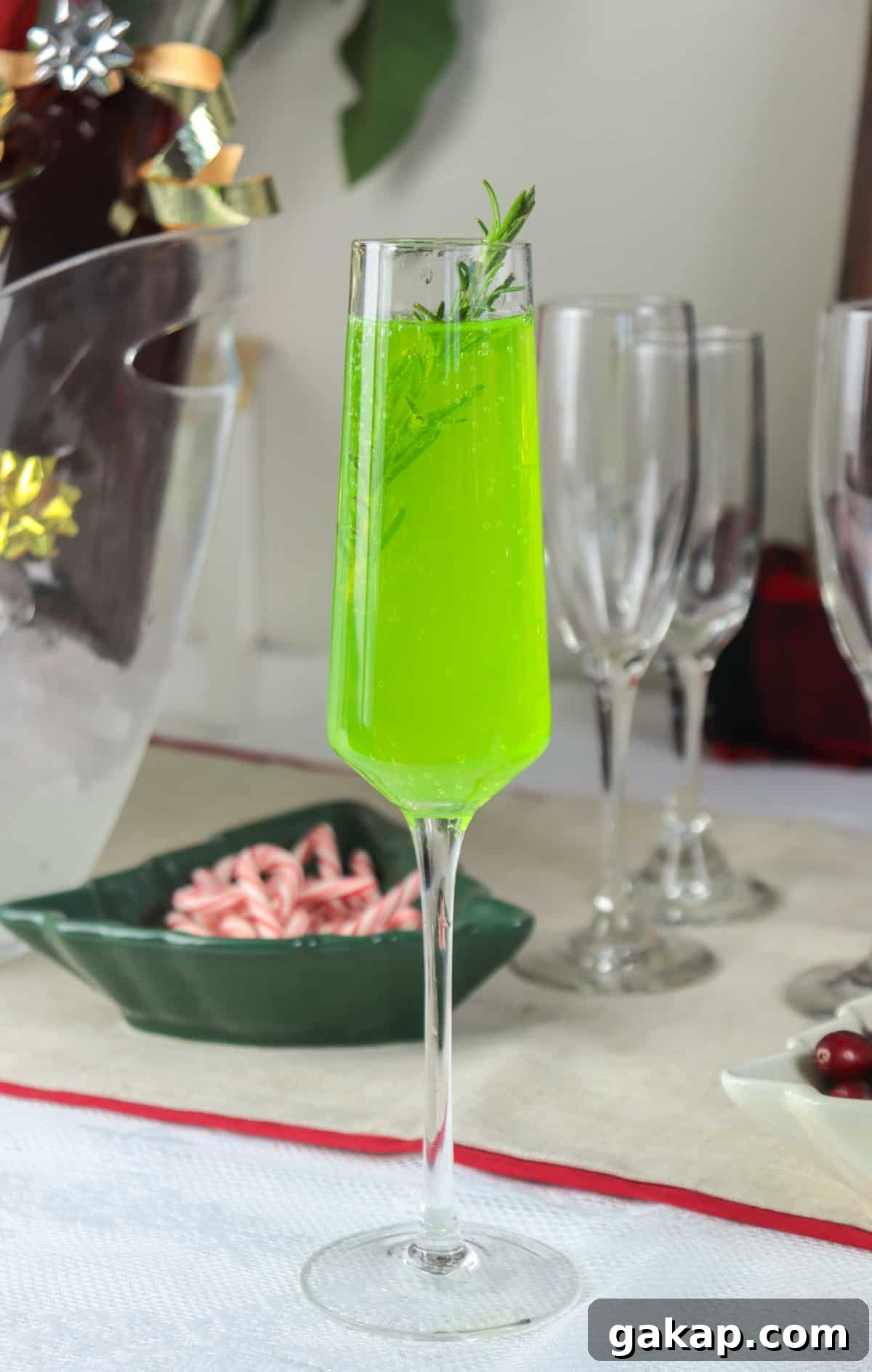 Green Grinch Mimosa Cocktail Recipe for Holiday Brunch 2 Green mimosa in a champagne glass.