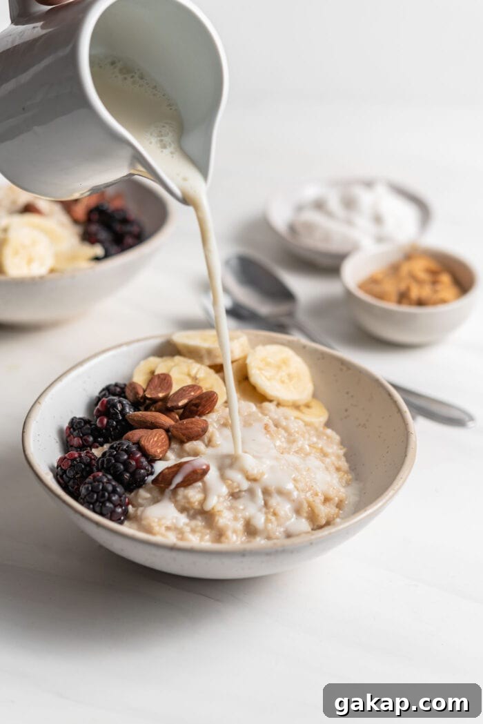 Pouring milk over a bowl of oatmeal.