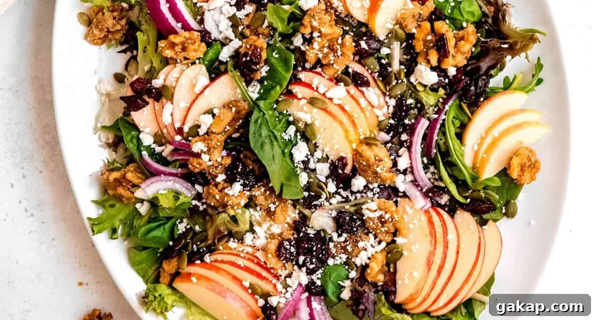 Overhead image of apple walnut salad on white dish with garnish. 