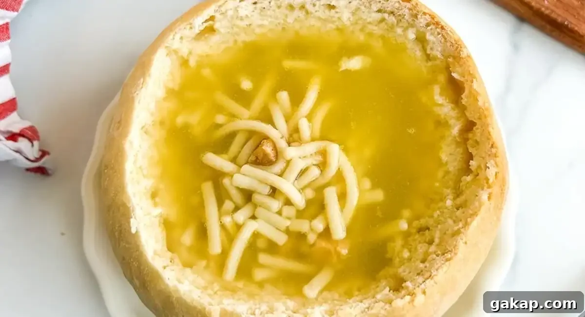 Overhead image of sourdough bread bowl with noodle soup. 