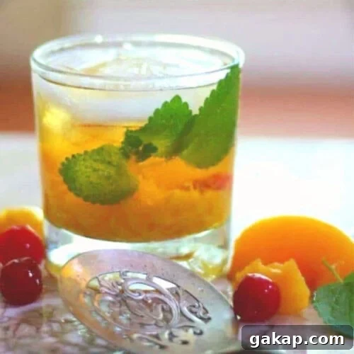 A glass with filled with peach whiskey mule cocktail.