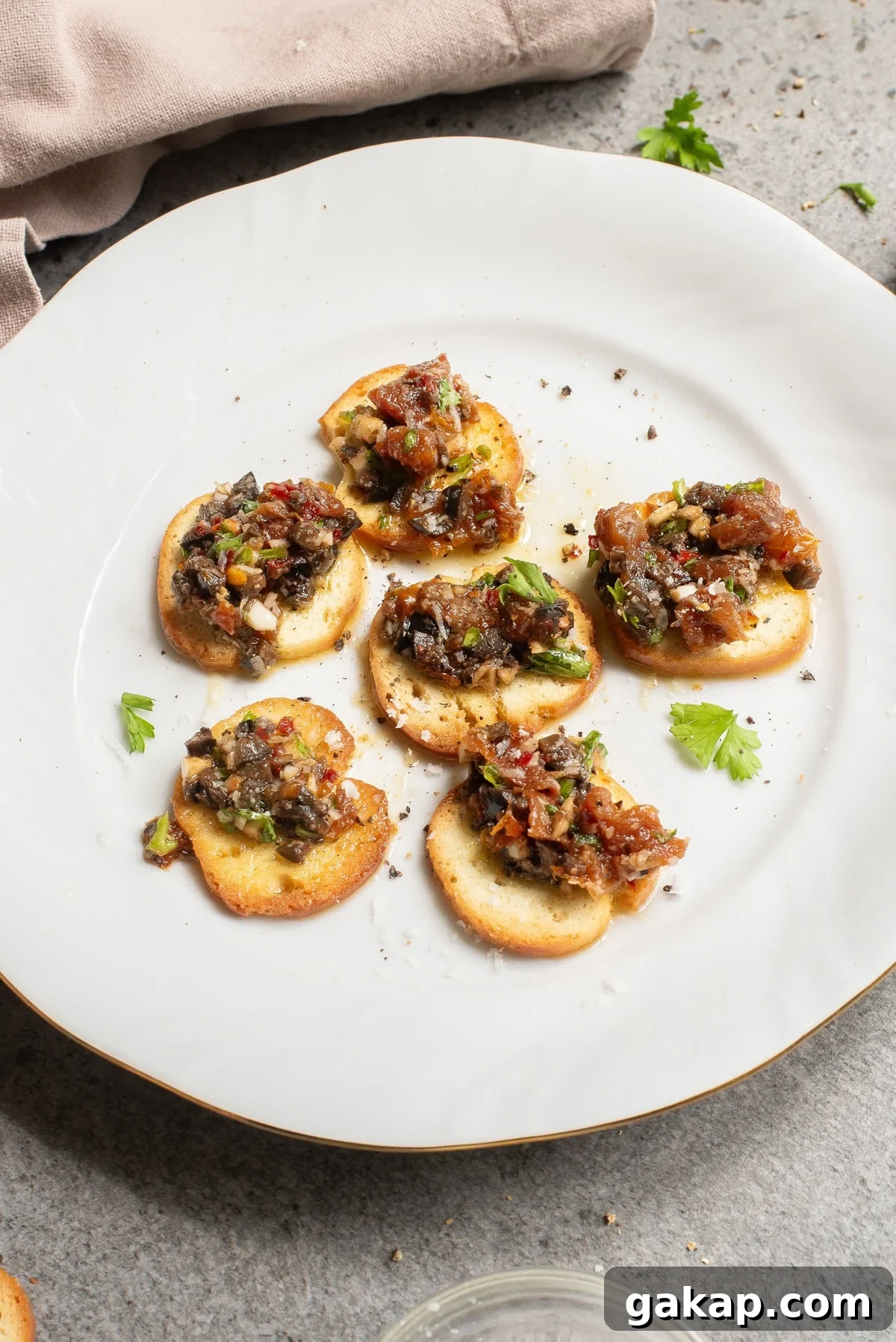 An overhead image of bread slices topped with olive oil dipping sauce.