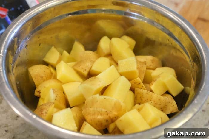Crispy Lemon-Herb Roasted Potatoes for Weeknight Meals 3 potatoes in a siler mixing bowl