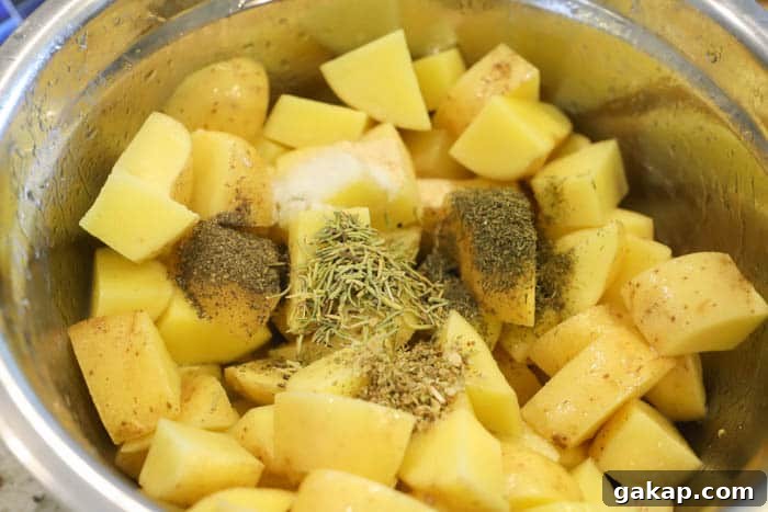 Crispy Lemon-Herb Roasted Potatoes for Weeknight Meals 4 potatoes in a bowl with seasoning