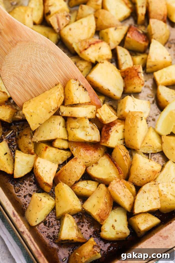 Crispy Lemon-Herb Roasted Potatoes for Weeknight Meals 6 Lemon Herb Roasted Potatoes on a pan with a wooden spoon