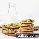 stack of fruitcake cookies on a cutting board with a bottle of milk in the background