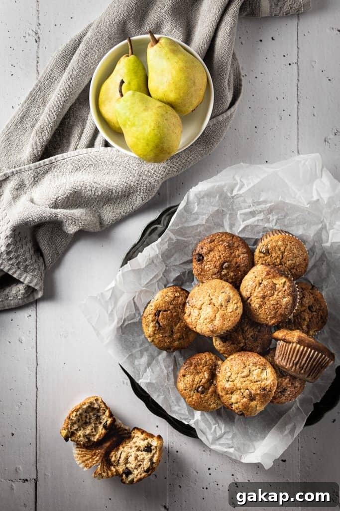 Banana Pear Muffins with Maple Glaze Recipe 2 Overhead view of a bowl of muffins, a bowl of pears and a cut open muffin