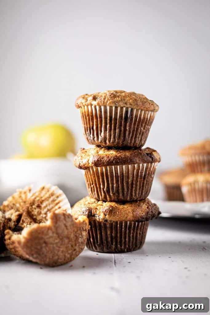 Banana Pear Muffins with Maple Glaze Recipe 4 Three banana and pear muffins stacked on top of each other, with a half eaten one lying in front