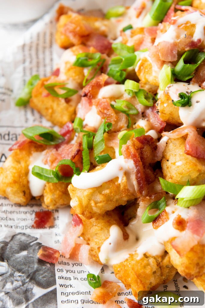 Loaded Tater Tots Recipe: Crispy, Cheesy Potato Bites 2 close up of loaded tater tots with bacon and green onion