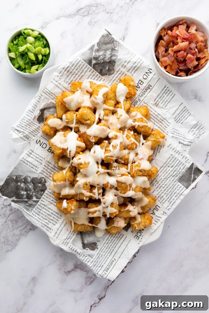 Loaded Tater Tots Recipe: Crispy, Cheesy Potato Bites 4 tater tots with sour cream drizzled on top